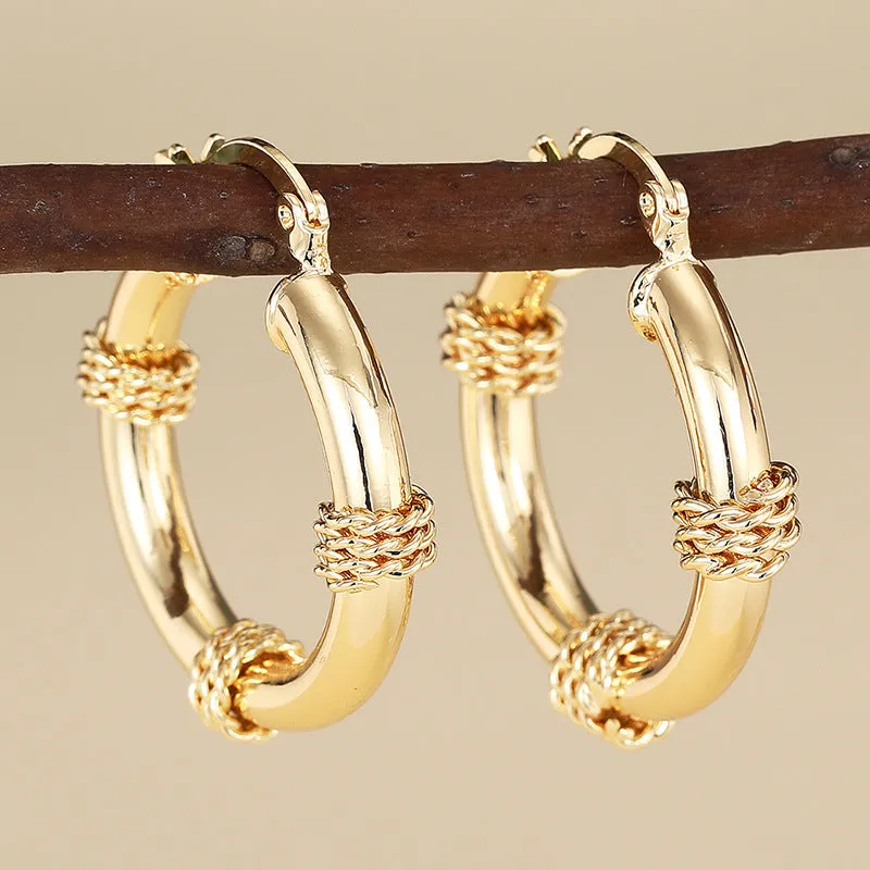 Geometric gold-coloured copper earrings with ring and line design elements