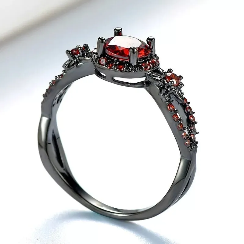 Black gold plated copper ring with round red zircon stone and wave-shaped band on finger