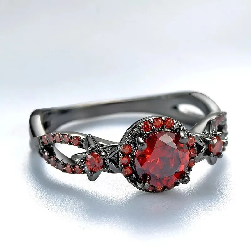 Black gold plated copper ring with round red zircon stone and wave-shaped band on finger
