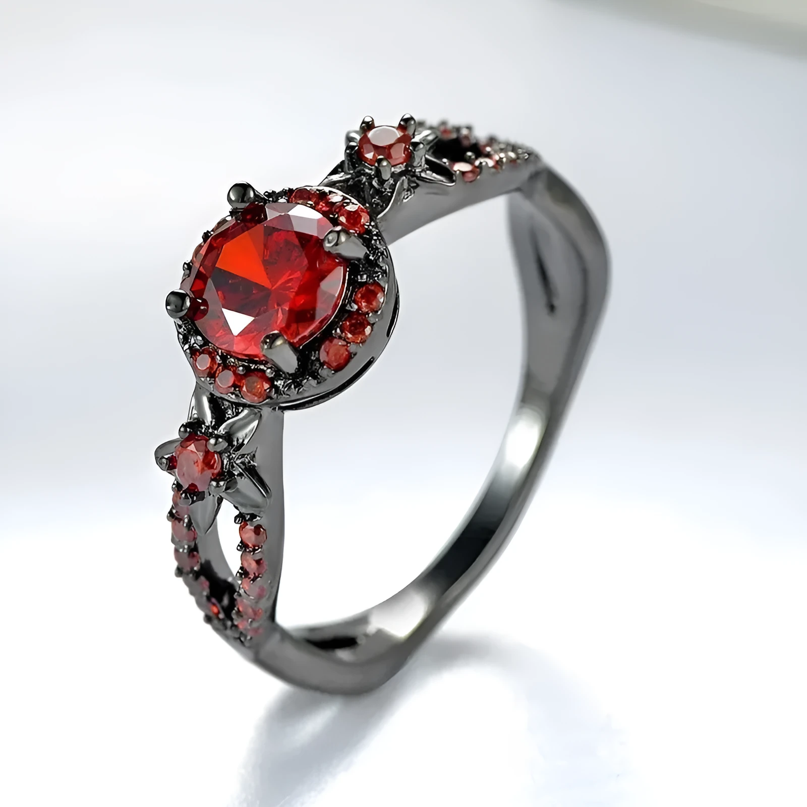 Black gold plated copper ring with round red zircon stone and wave-shaped band on finger