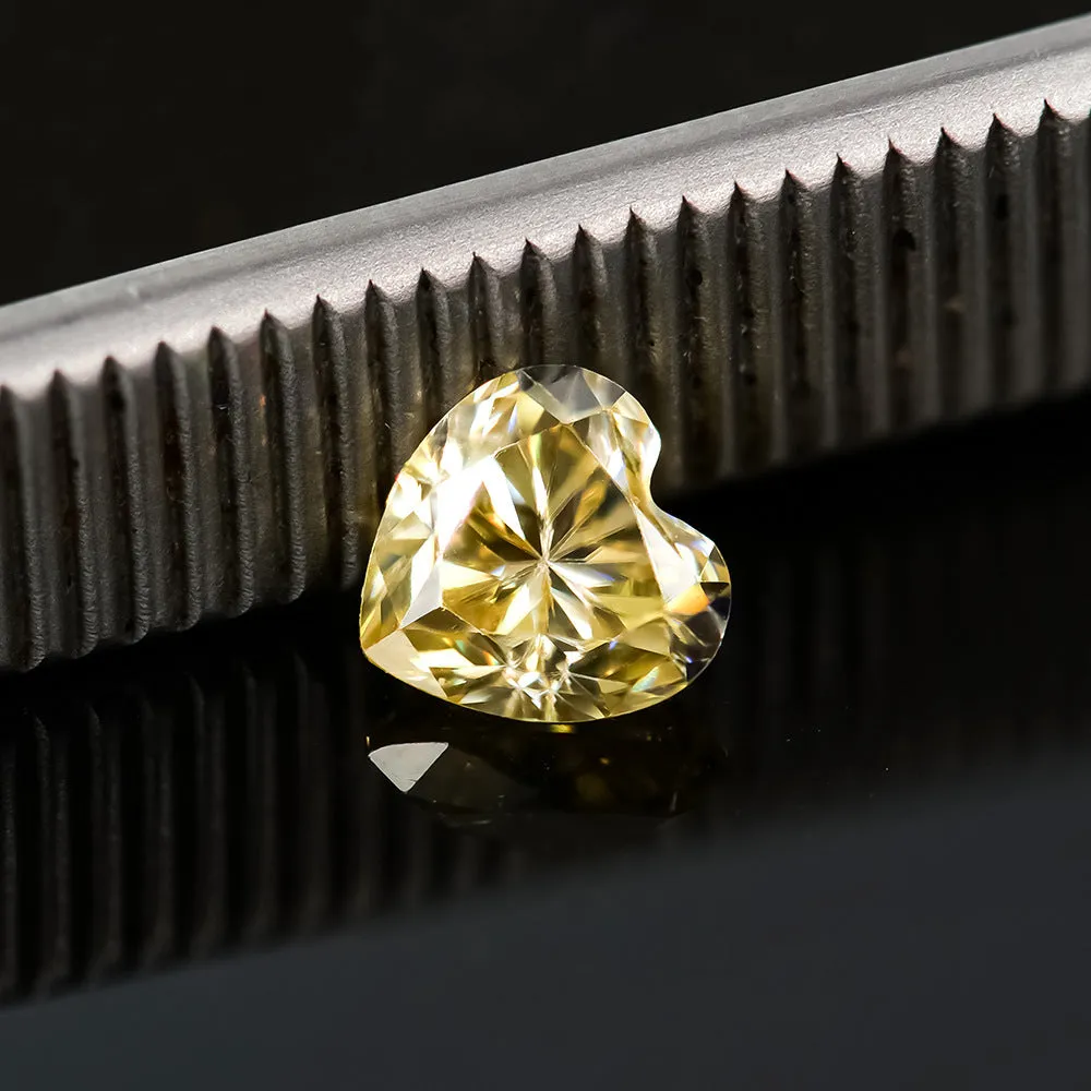 Loose lemon yellow heart-shaped moissanite stone on a plain background.