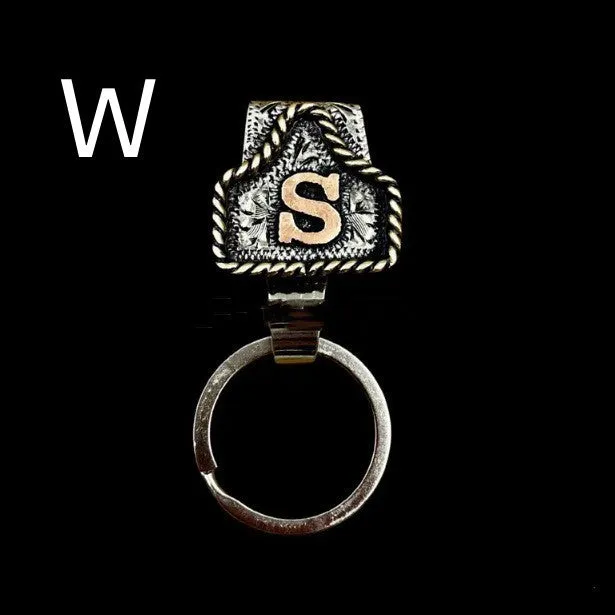 Handmade cow tag shaped metal keychain with a brown leather attachment strap.