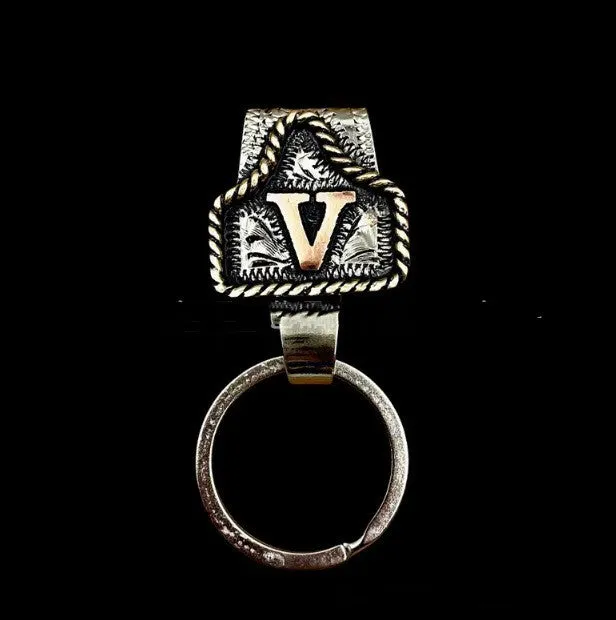 Handmade cow tag shaped metal keychain with a brown leather attachment strap.
