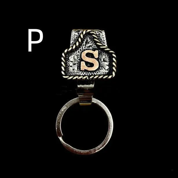 Handmade cow tag shaped metal keychain with a brown leather attachment strap.