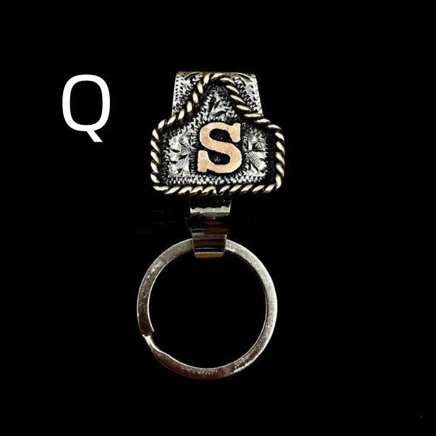 Handmade cow tag shaped metal keychain with a brown leather attachment strap.