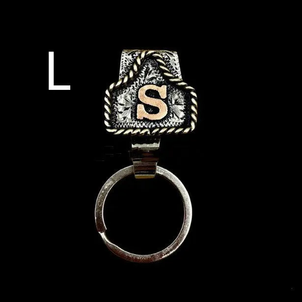 Handmade cow tag shaped metal keychain with a brown leather attachment strap.