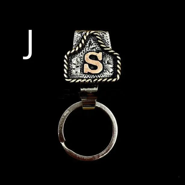 Handmade cow tag shaped metal keychain with a brown leather attachment strap.