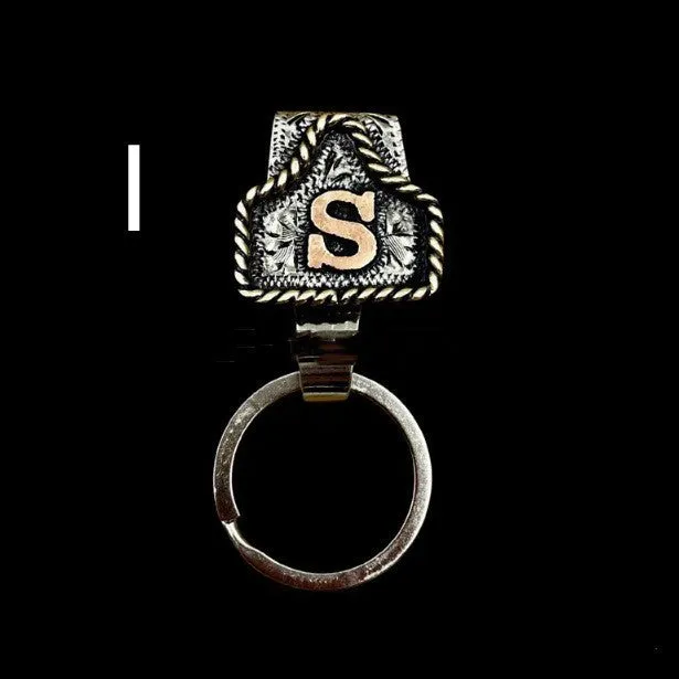 Handmade cow tag shaped metal keychain with a brown leather attachment strap.