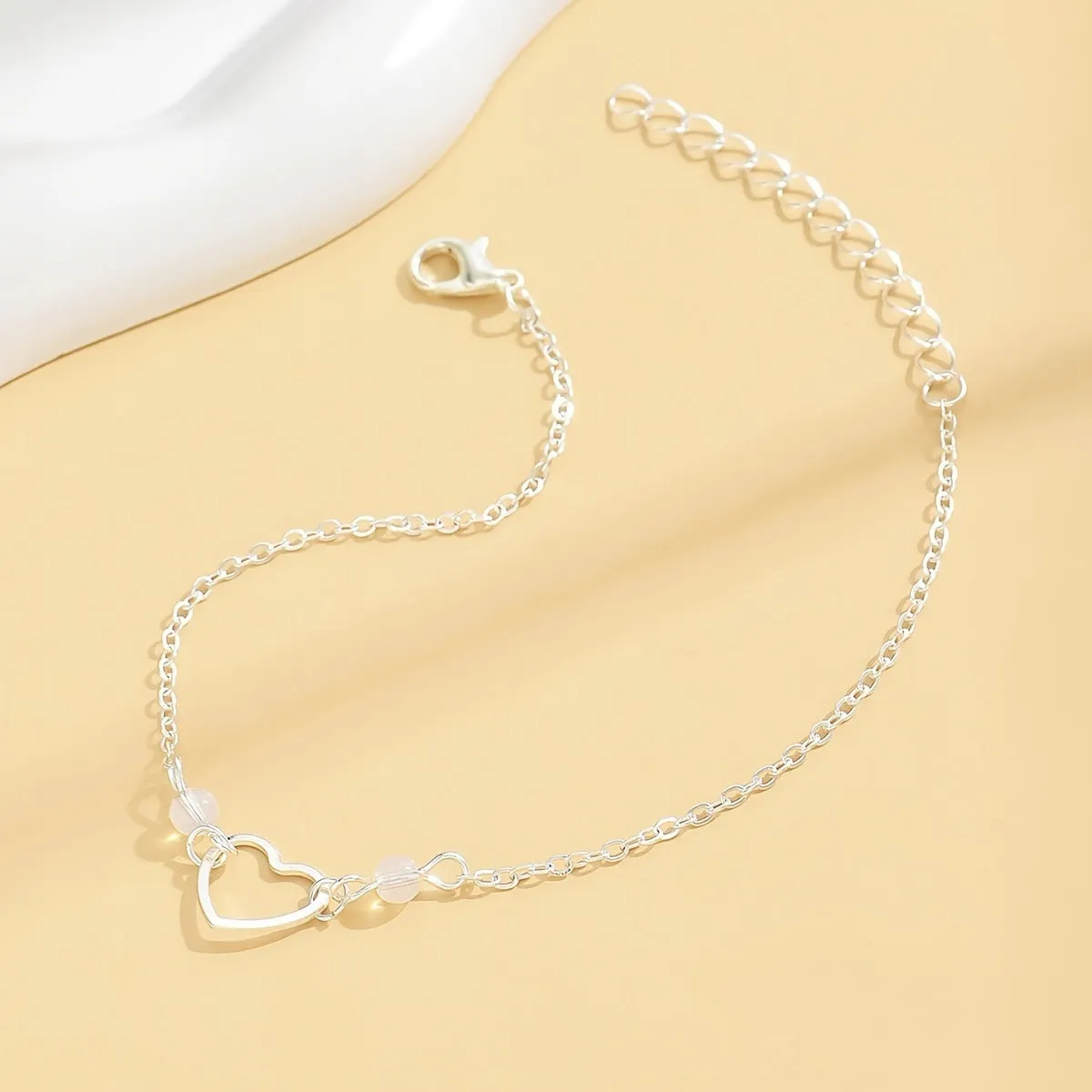 Adjustable women's anklet with heart-shaped pendant in gold or silver finish