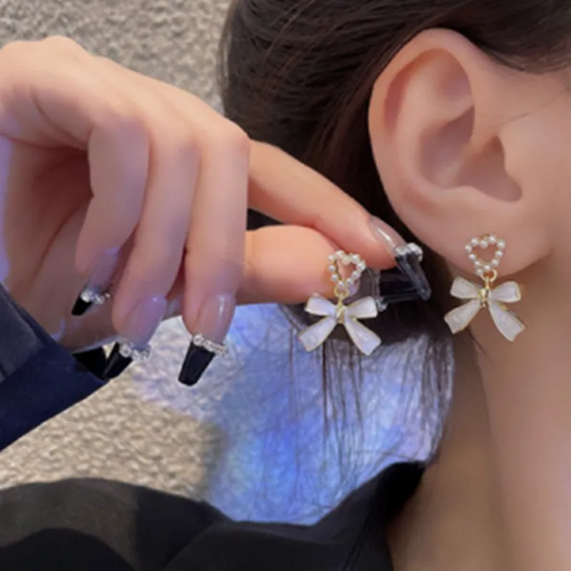 Gold-toned zinc alloy pearl bow drop earrings with electroplated finish, 2.4 by 1.9 cm