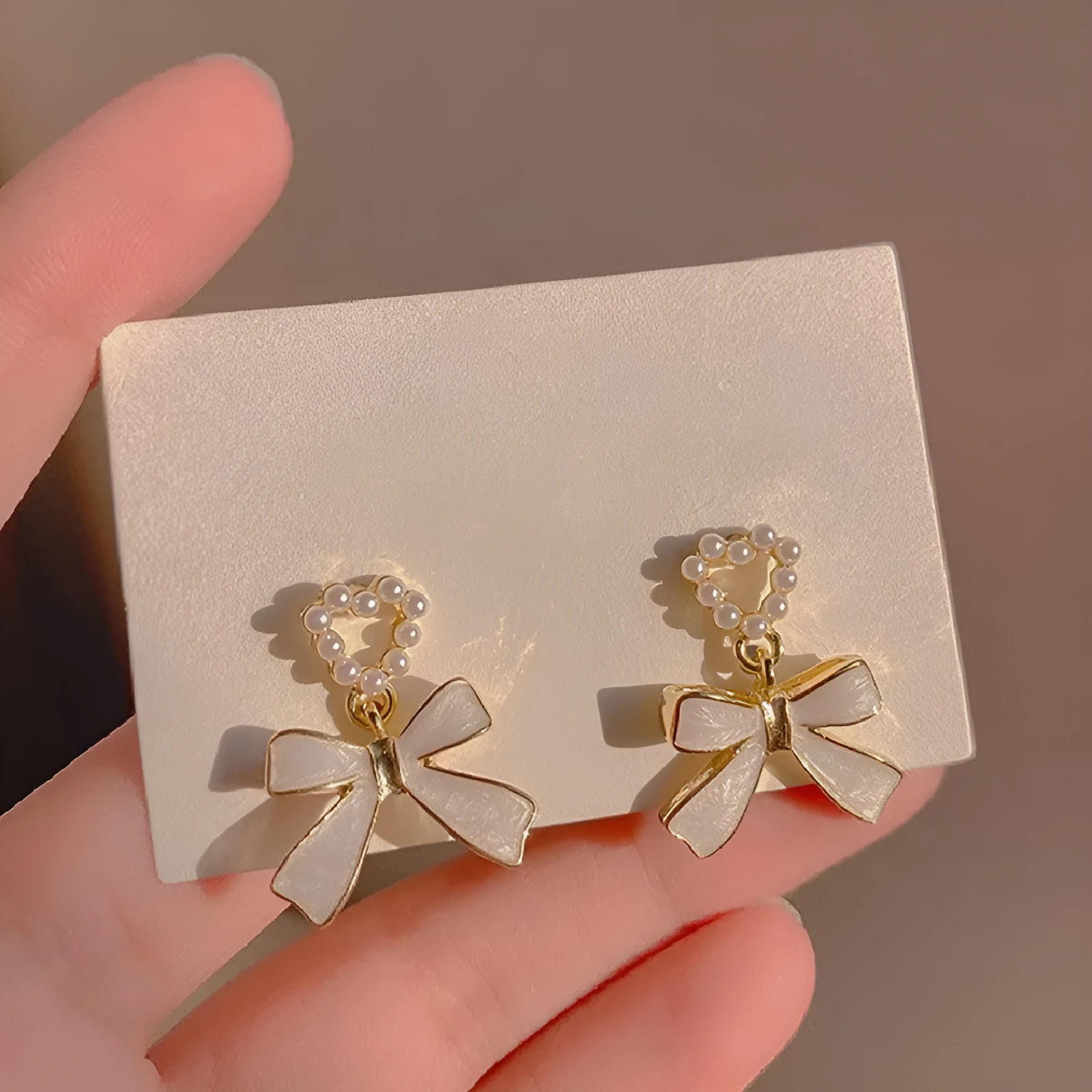 Gold-toned zinc alloy pearl bow drop earrings with electroplated finish, 2.4 by 1.9 cm