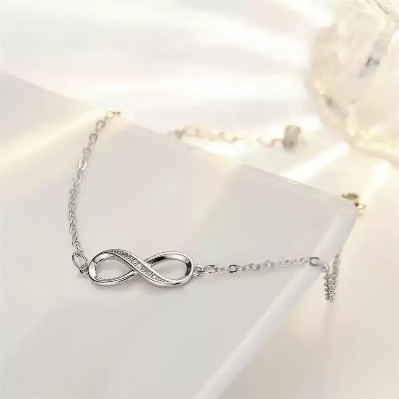 Silver copper Mobius strip diamond ring push-pull bracelet with lucky cat charm on display.