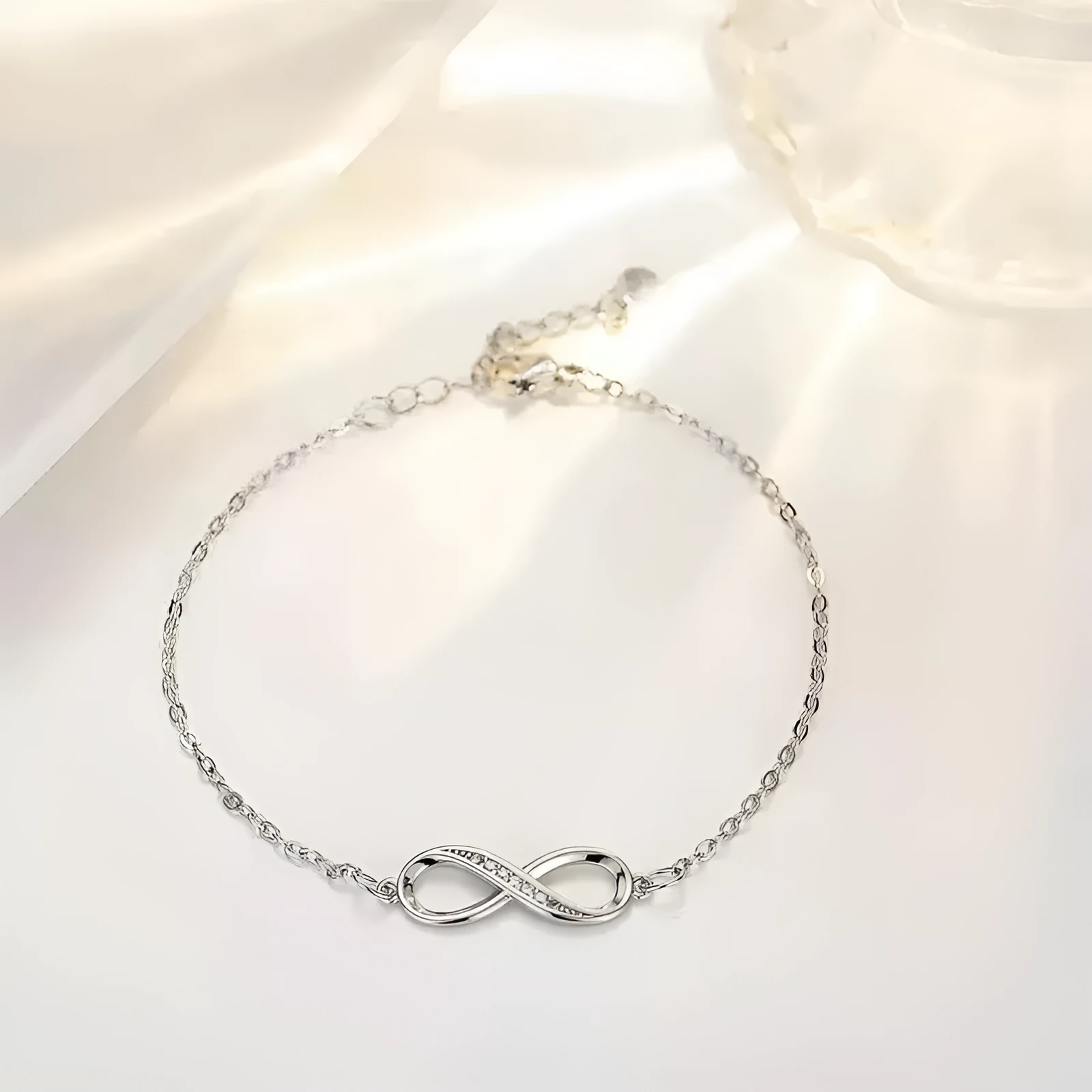 Silver copper Mobius strip diamond ring push-pull bracelet with lucky cat charm on display.