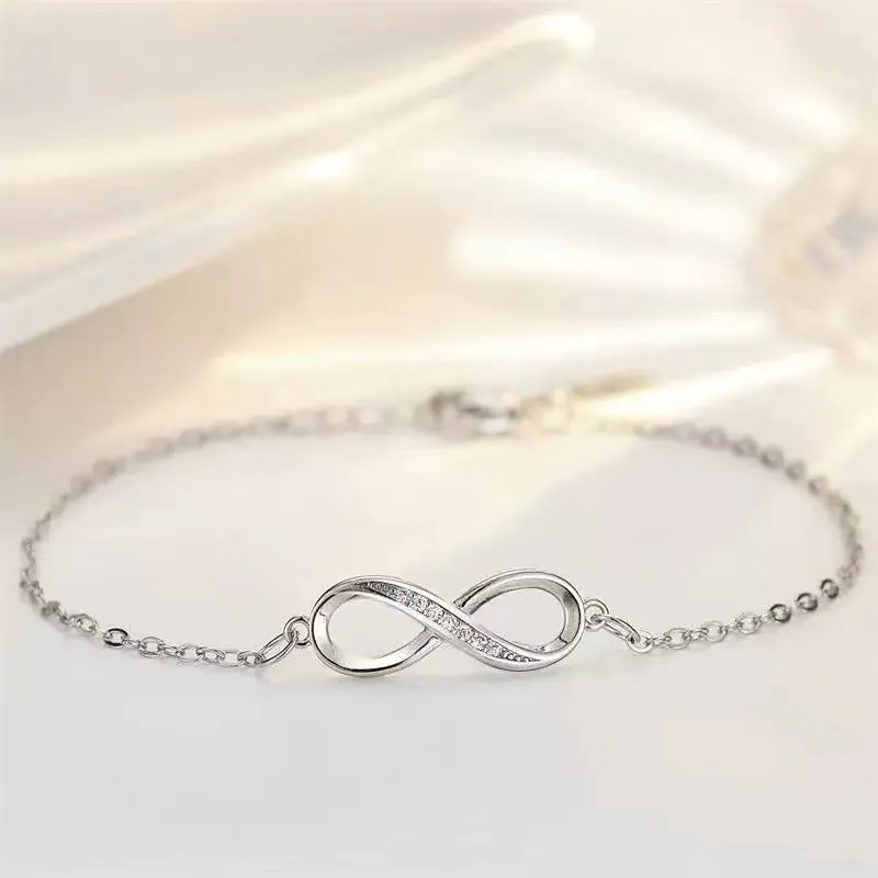 Silver copper Mobius strip diamond ring push-pull bracelet with lucky cat charm on display.