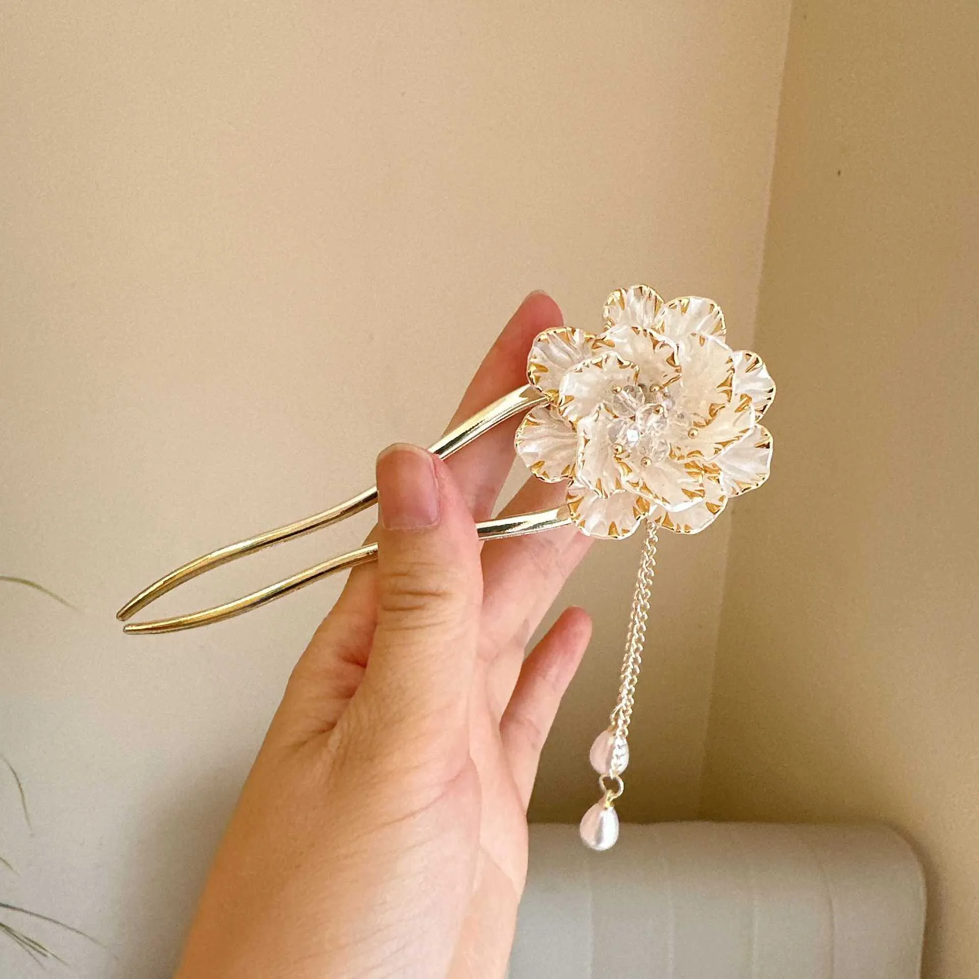 Close-up of a purple alloy U-shaped hairpin with a detailed peony flower and tassel design on a white background.