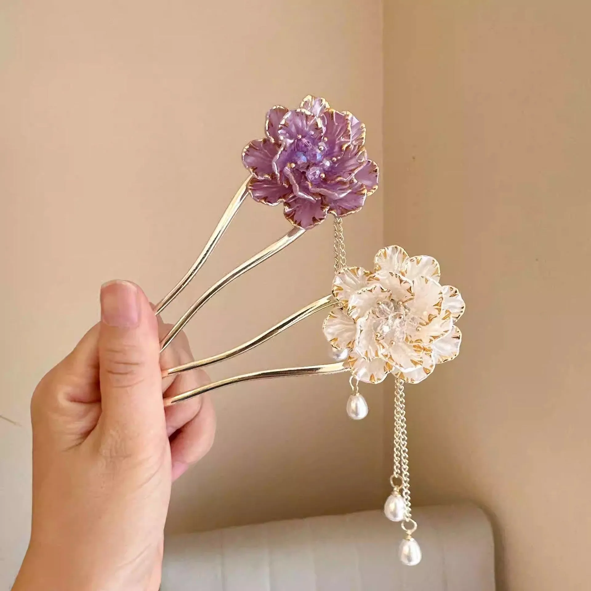 Close-up of a purple alloy U-shaped hairpin with a detailed peony flower and tassel design on a white background.