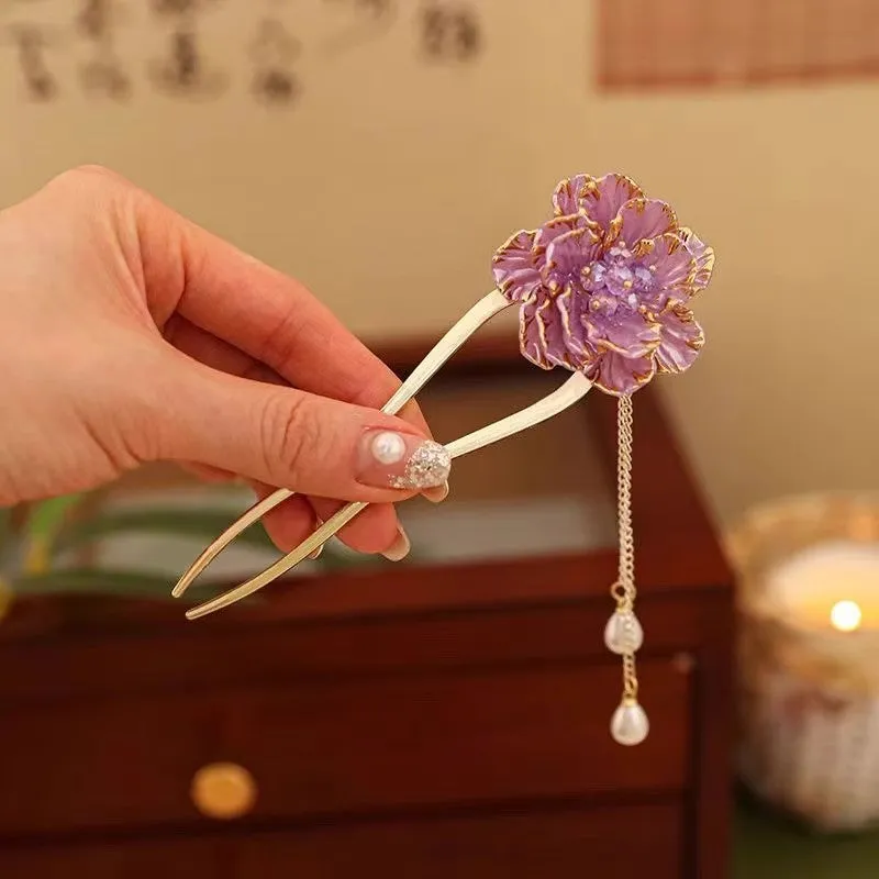 Close-up of a purple alloy U-shaped hairpin with a detailed peony flower and tassel design on a white background.