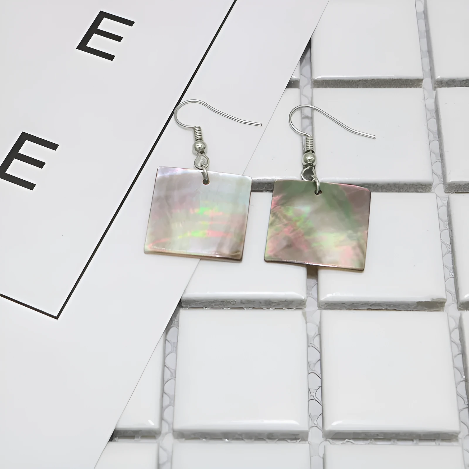 Women's geometric shell earrings showing rectangular and square shapes with natural shell material texture