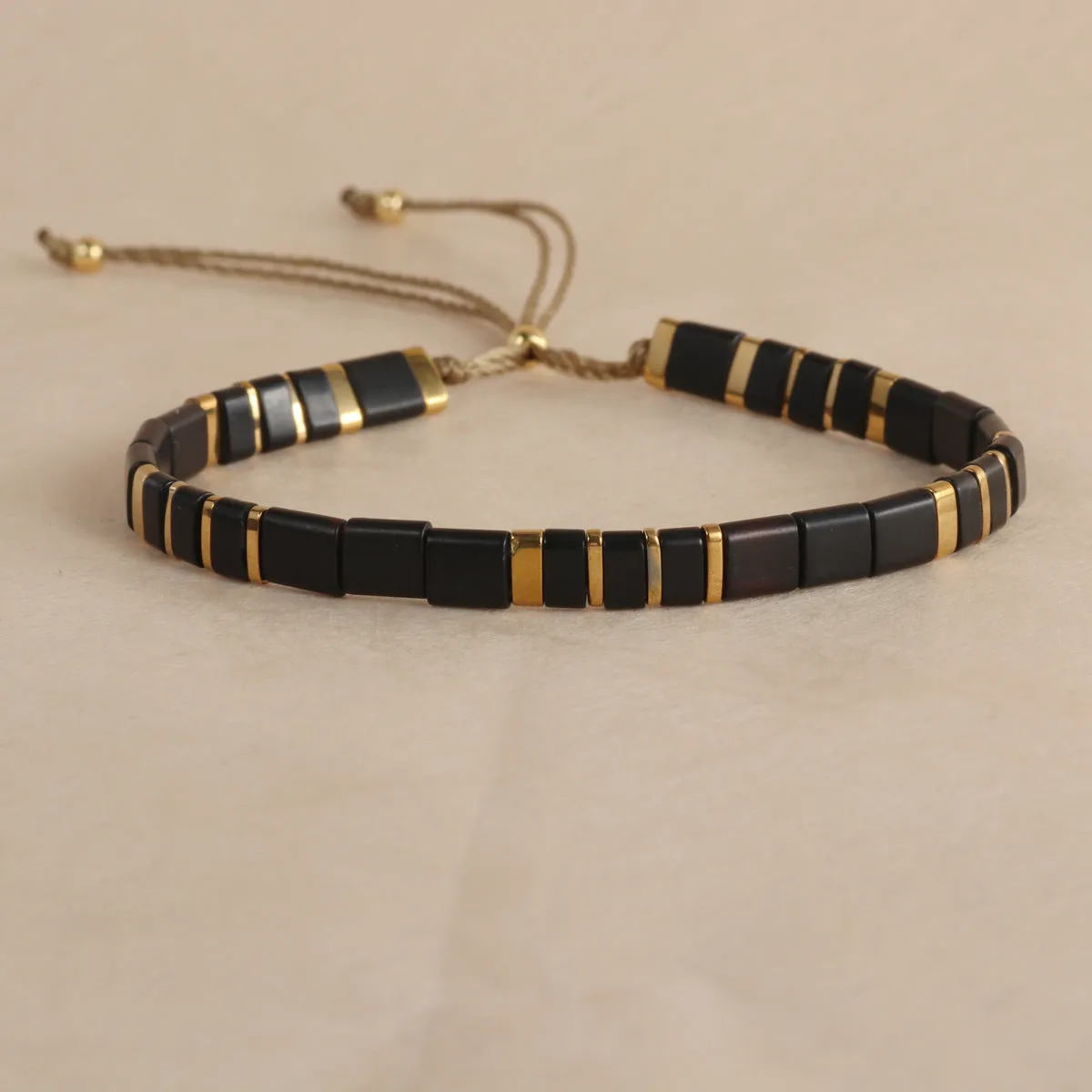 Geometric round glass bead bracelet in five colour options on a wrist.