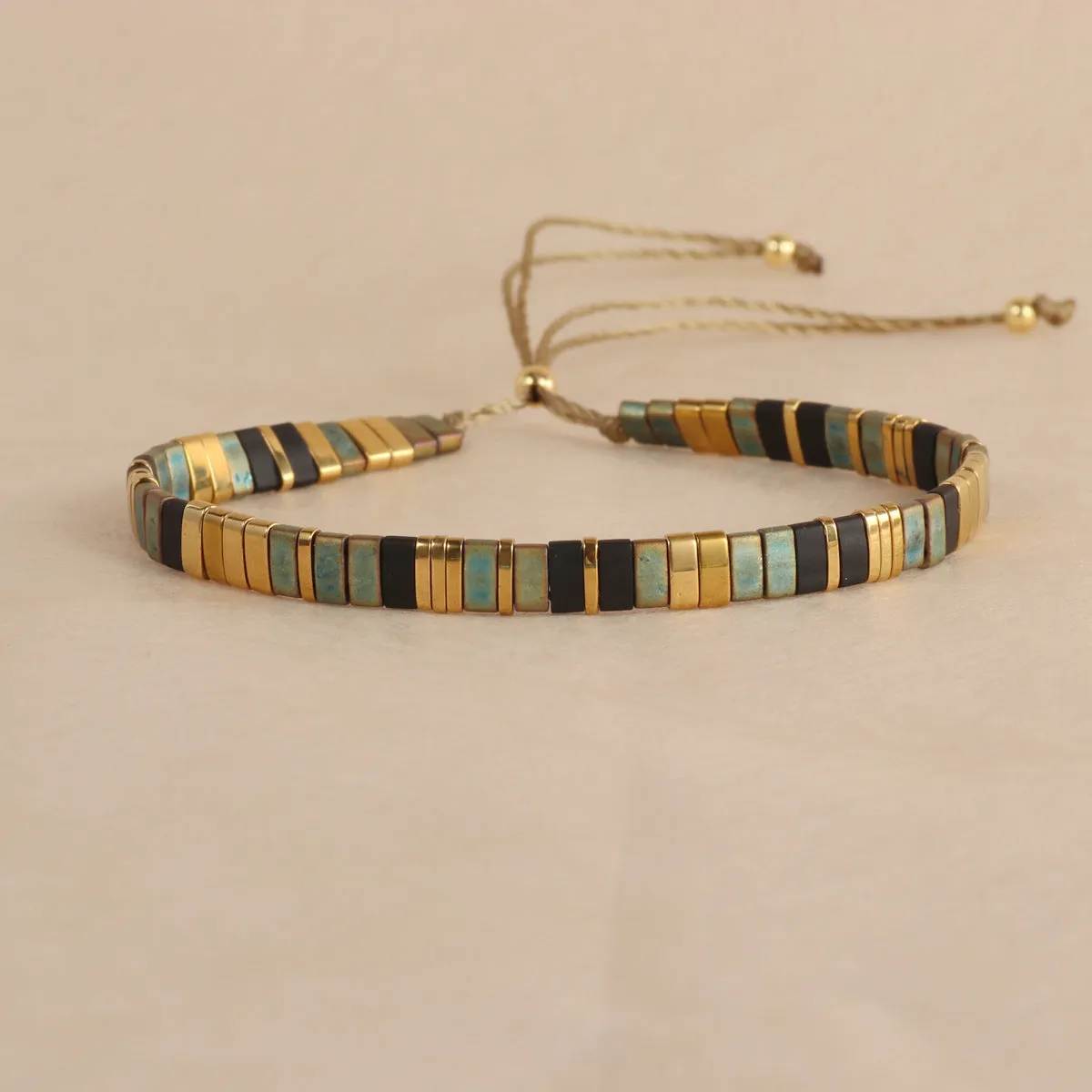 Geometric round glass bead bracelet in five colour options on a wrist.