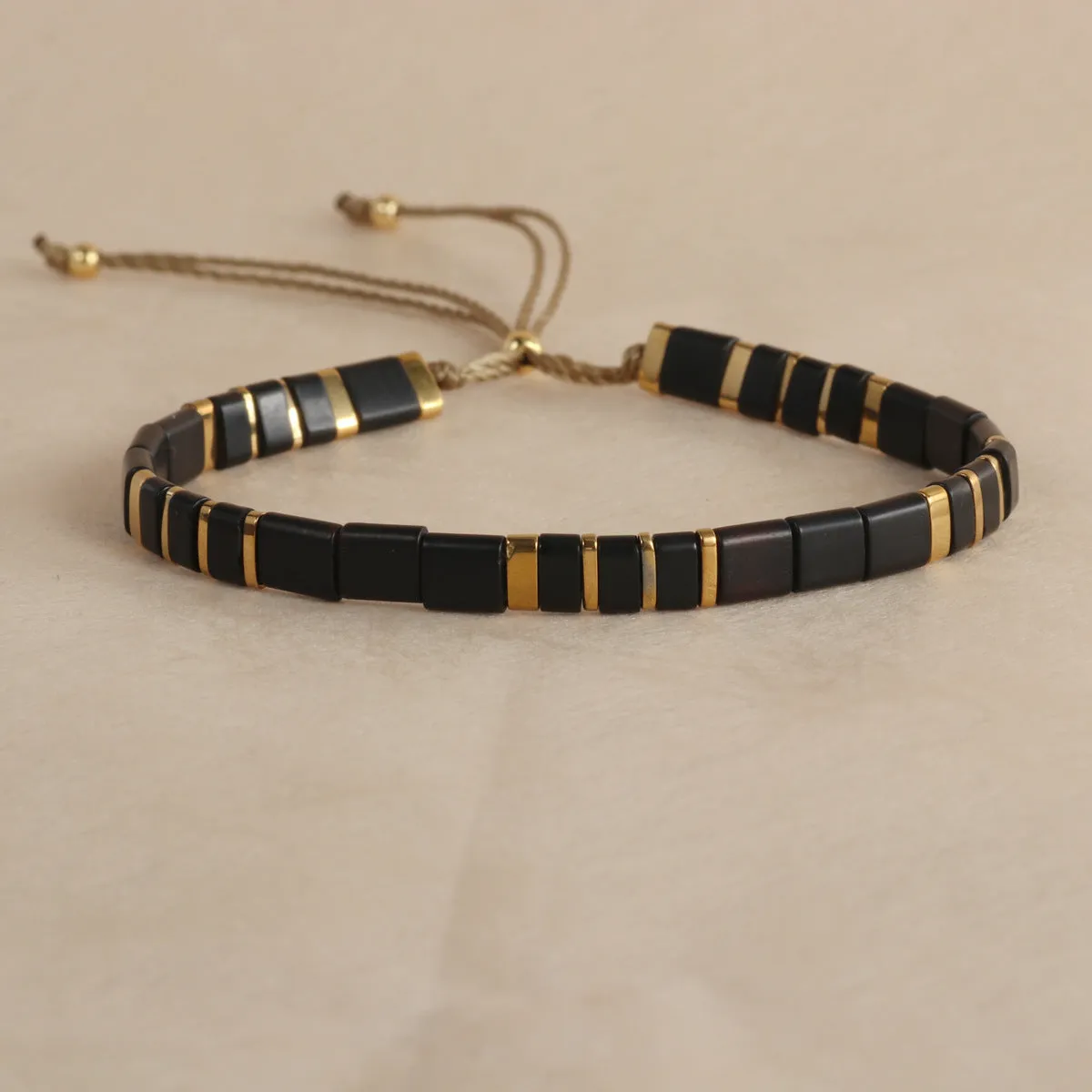 Geometric round glass bead bracelet in five colour options on a wrist.