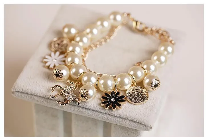 White pearl flower bracelet with simulated pearl beads, floral design, 17cm length, on a soft surface