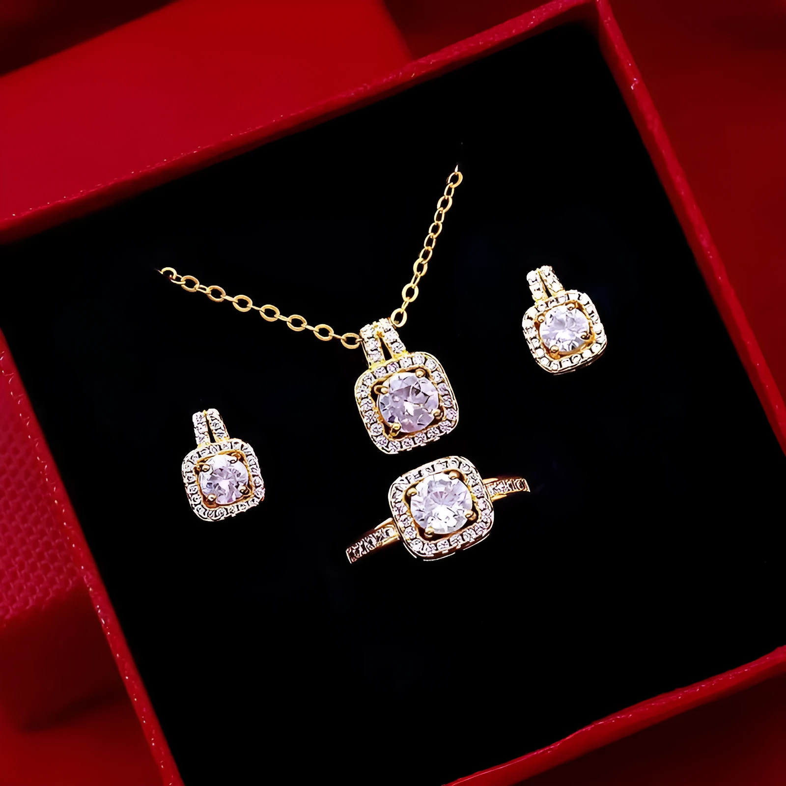 Gold-tone fashion jewellery set with zircon pendant necklace, stud earrings, and ring on white background