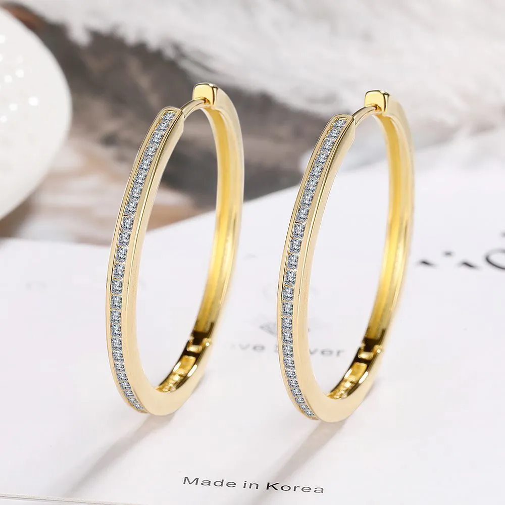 Gold-toned copper clip-on earring with round geometric shape and inlaid zircon stone
