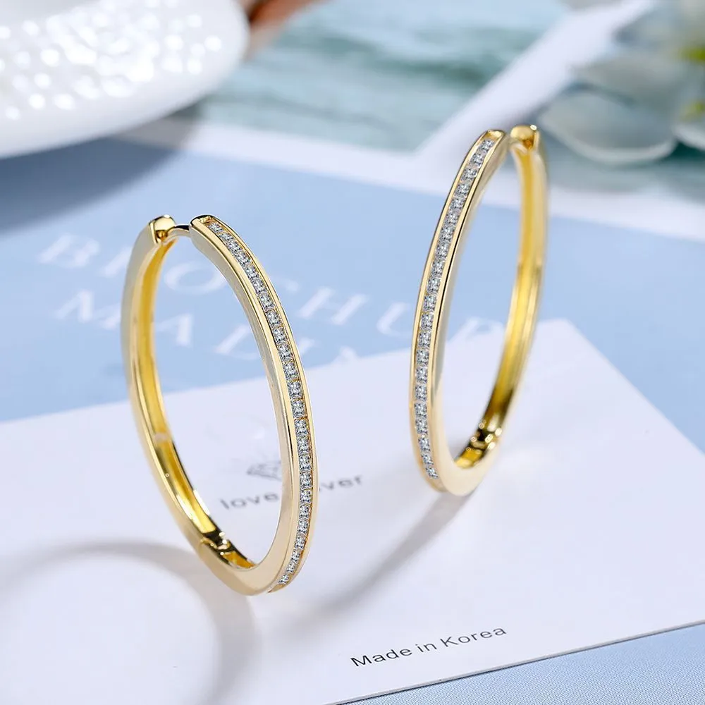Gold-toned copper clip-on earring with round geometric shape and inlaid zircon stone