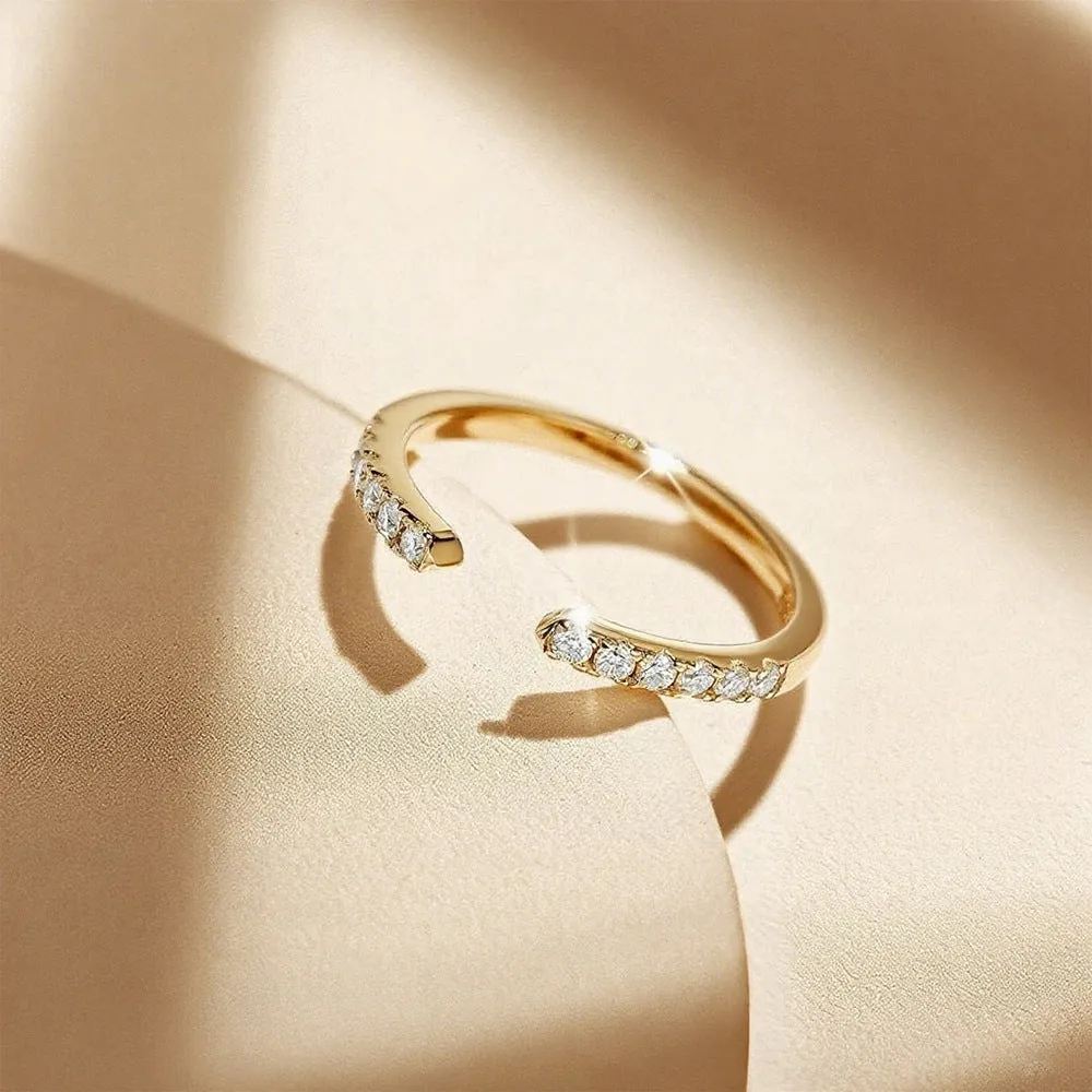 Silver adjustable opening ring with electroplated gold finish, geometric shape with round element on plain background