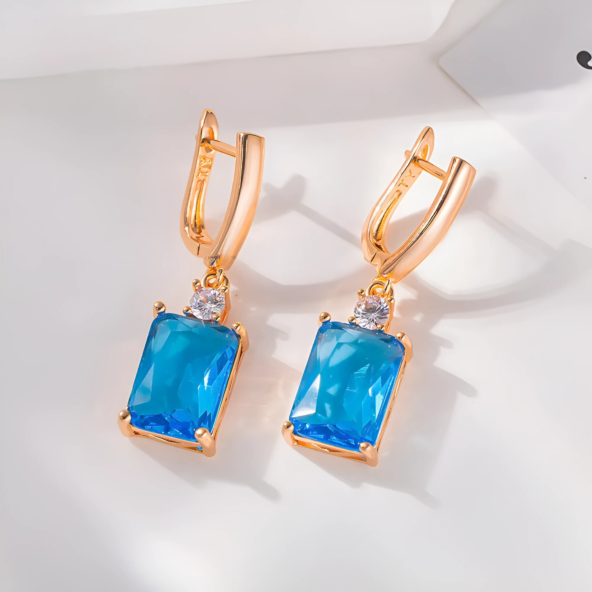 A pair of square gold or silver electroplated copper earrings with geometric design.
