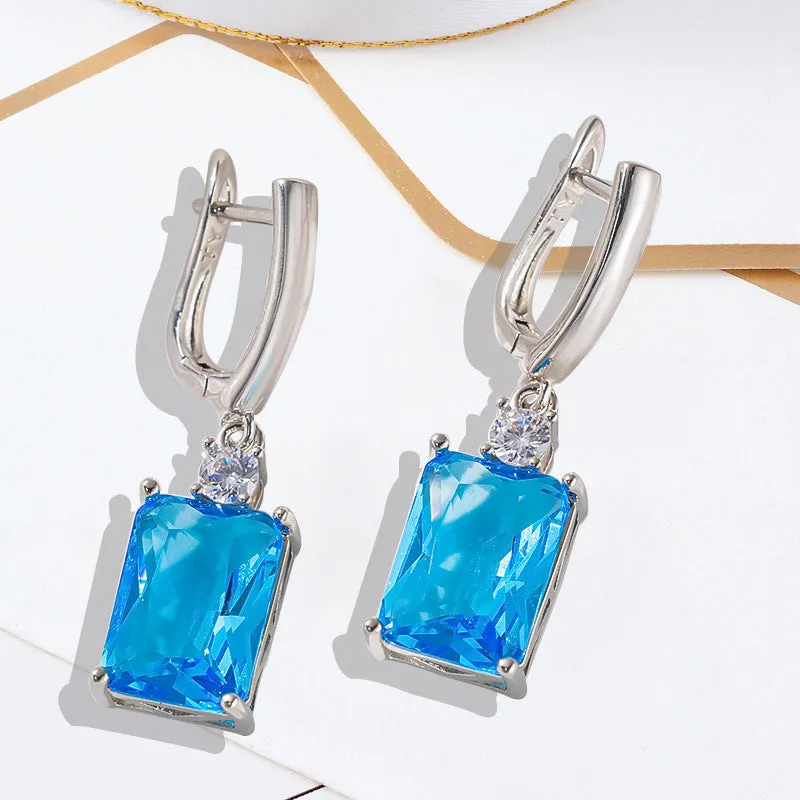 A pair of square gold or silver electroplated copper earrings with geometric design.