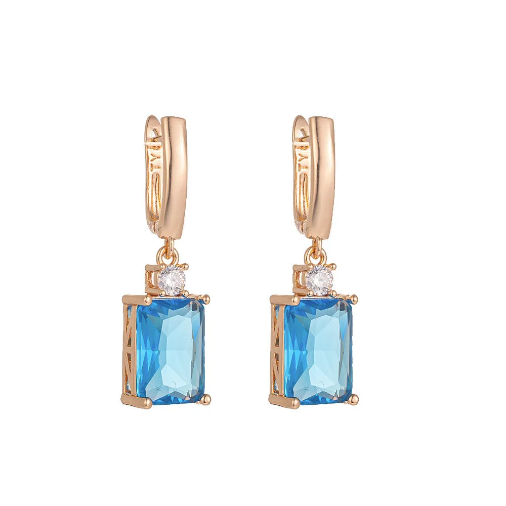 A pair of square gold or silver electroplated copper earrings with geometric design.