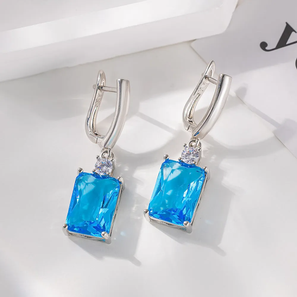 A pair of square gold or silver electroplated copper earrings with geometric design.