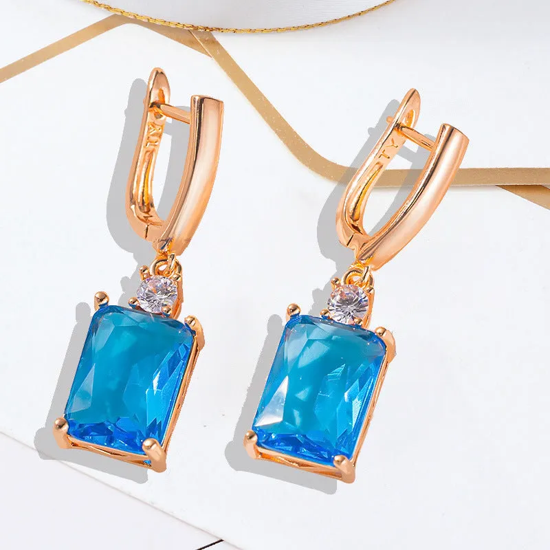 A pair of square gold or silver electroplated copper earrings with geometric design.