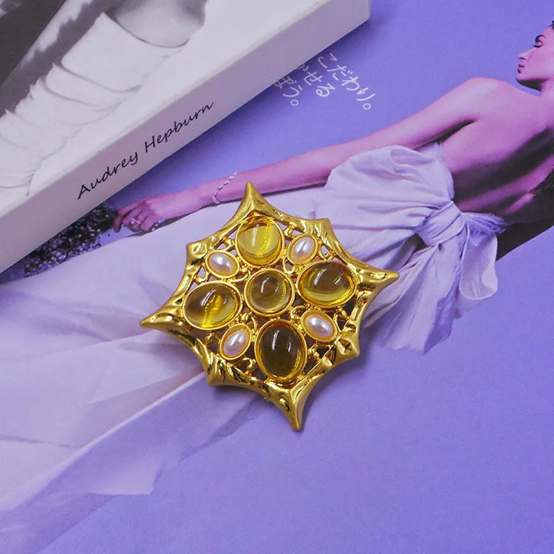 Close-up of a vintage medieval baroque style zinc alloy brooch with a crystal cross centrepiece.