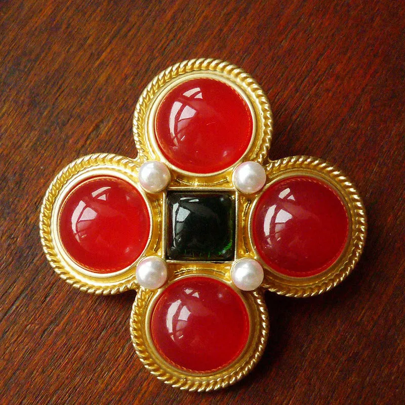 A selection of eight different zinc alloy retro baroque brooches in a diamond shape on a fabric background.