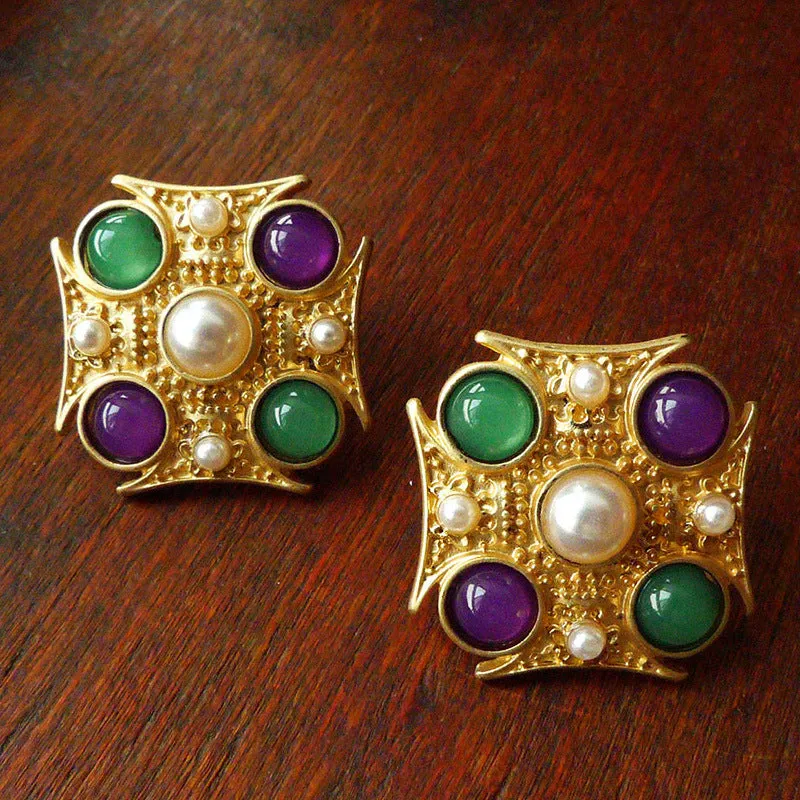 A selection of eight different zinc alloy retro baroque brooches in a diamond shape on a fabric background.