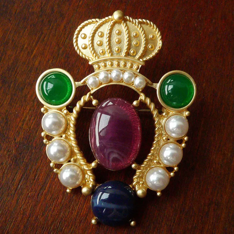 A selection of eight different zinc alloy retro baroque brooches in a diamond shape on a fabric background.