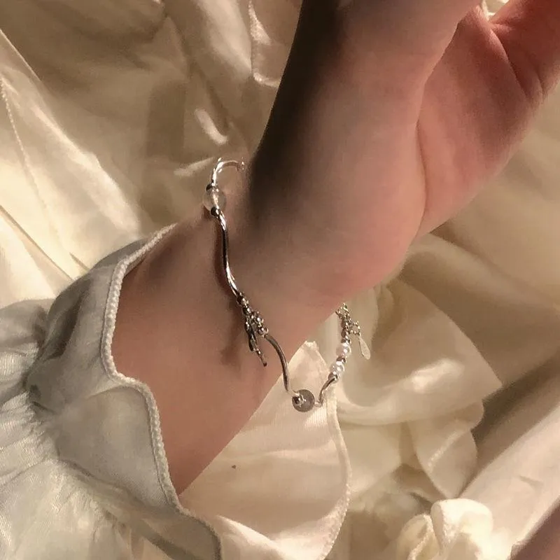 Pearl fishtail bracelet with irregular asymmetric bow in alloy