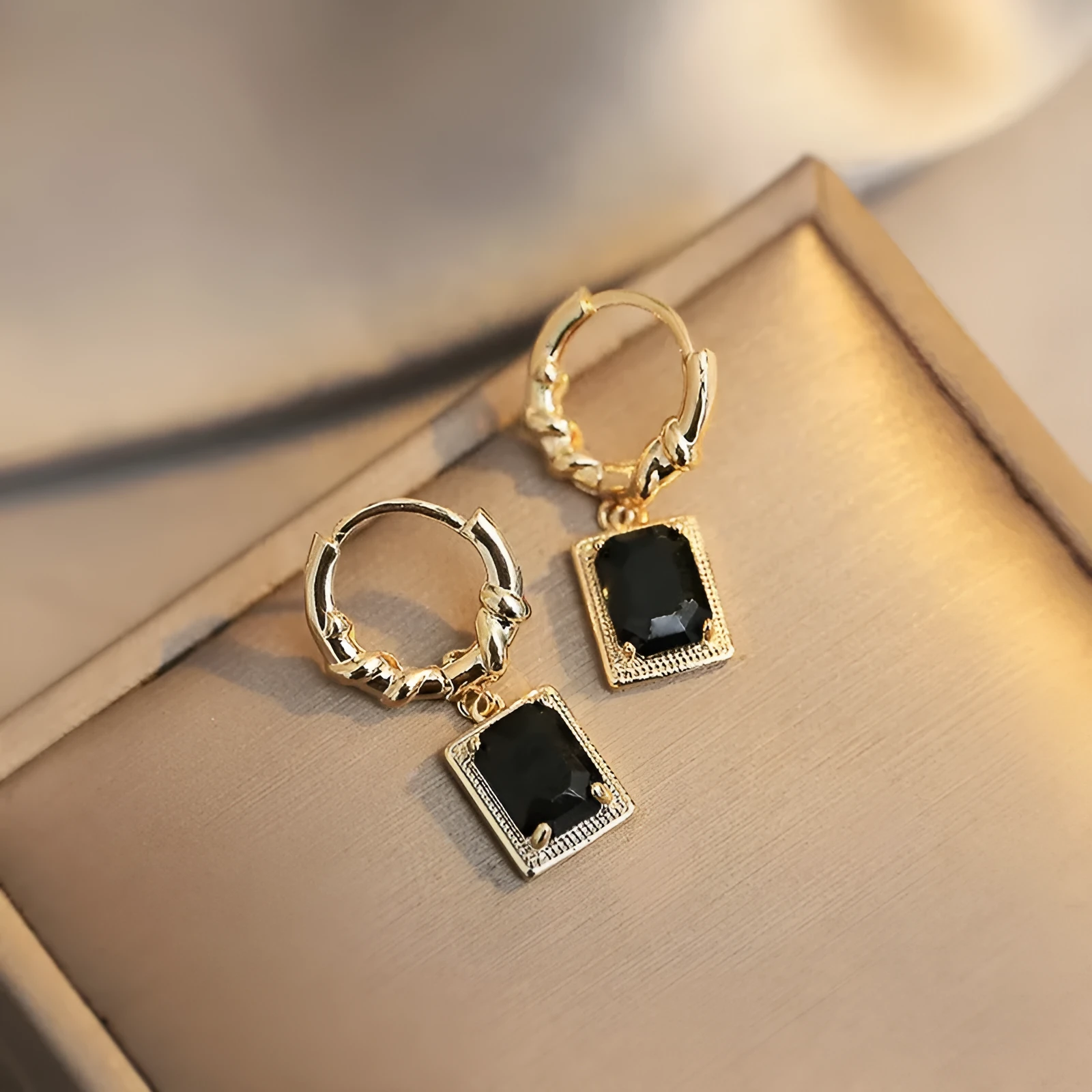 A pair of geometric black quadrilateral copper earrings with a zircon stone in a retro French court style.