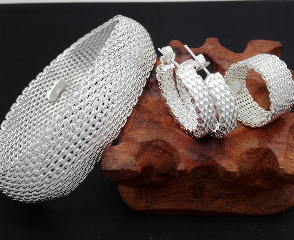 Retro copper net bracelet earring ring three-piece set on a flat surface