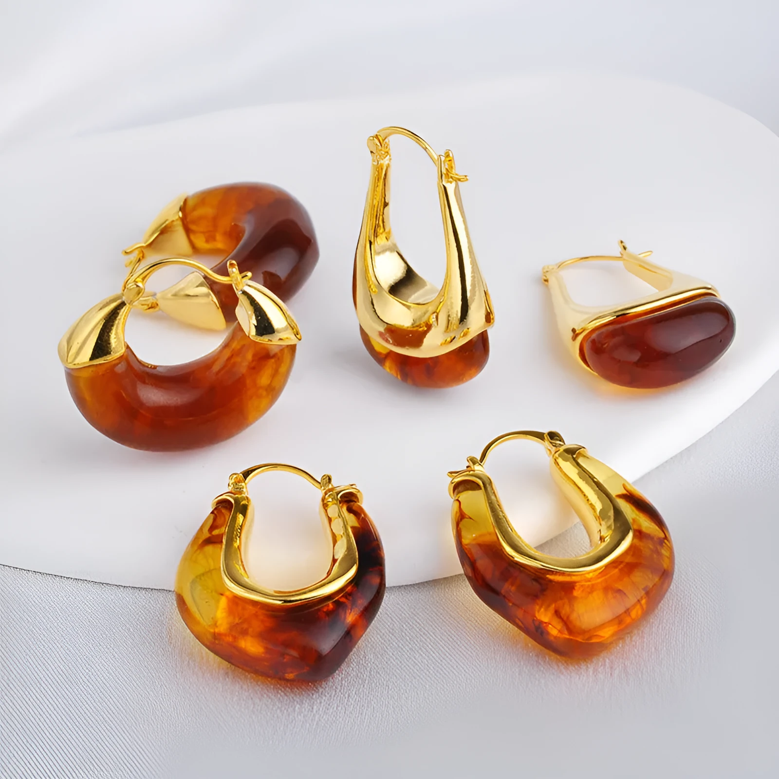 Copper geometry shape retro Maillard style earrings with electroplated finish in amber colour option on plain background