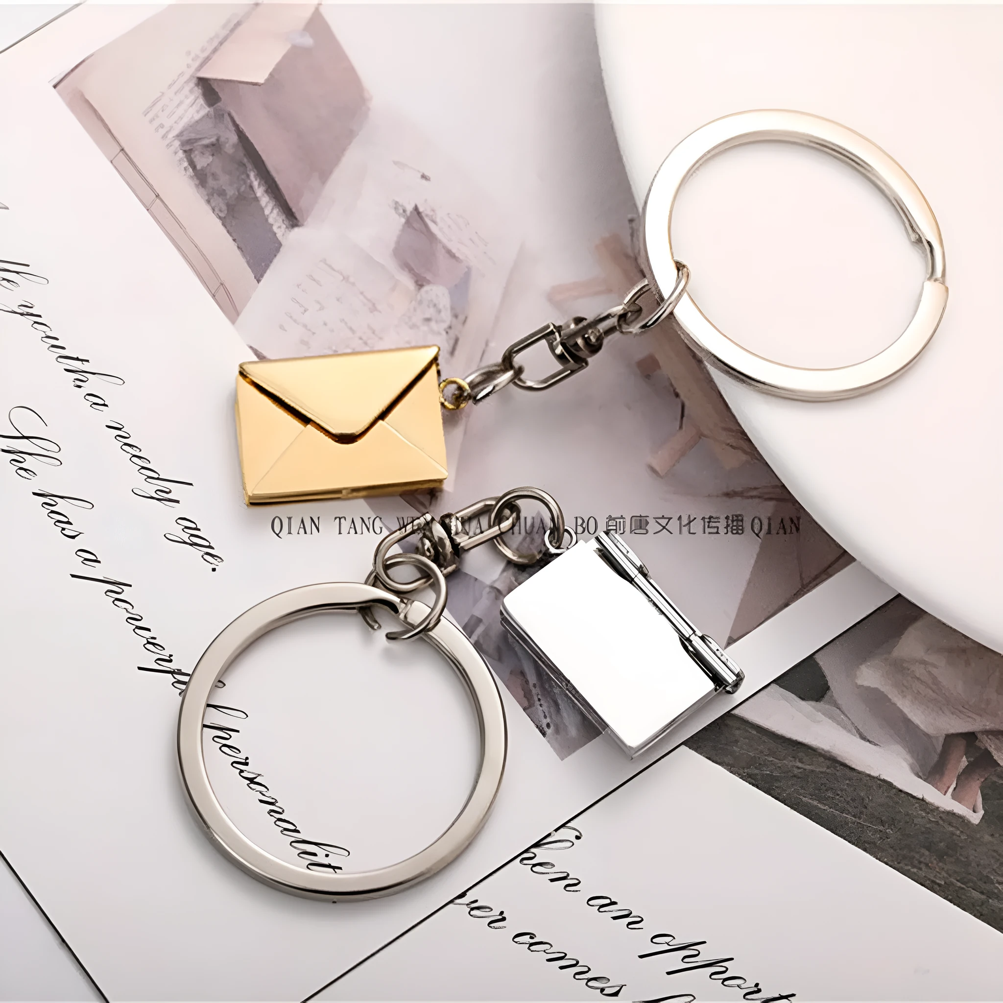 Stainless steel keychain with engraved card inside in gold and silver envelope finish on neutral background