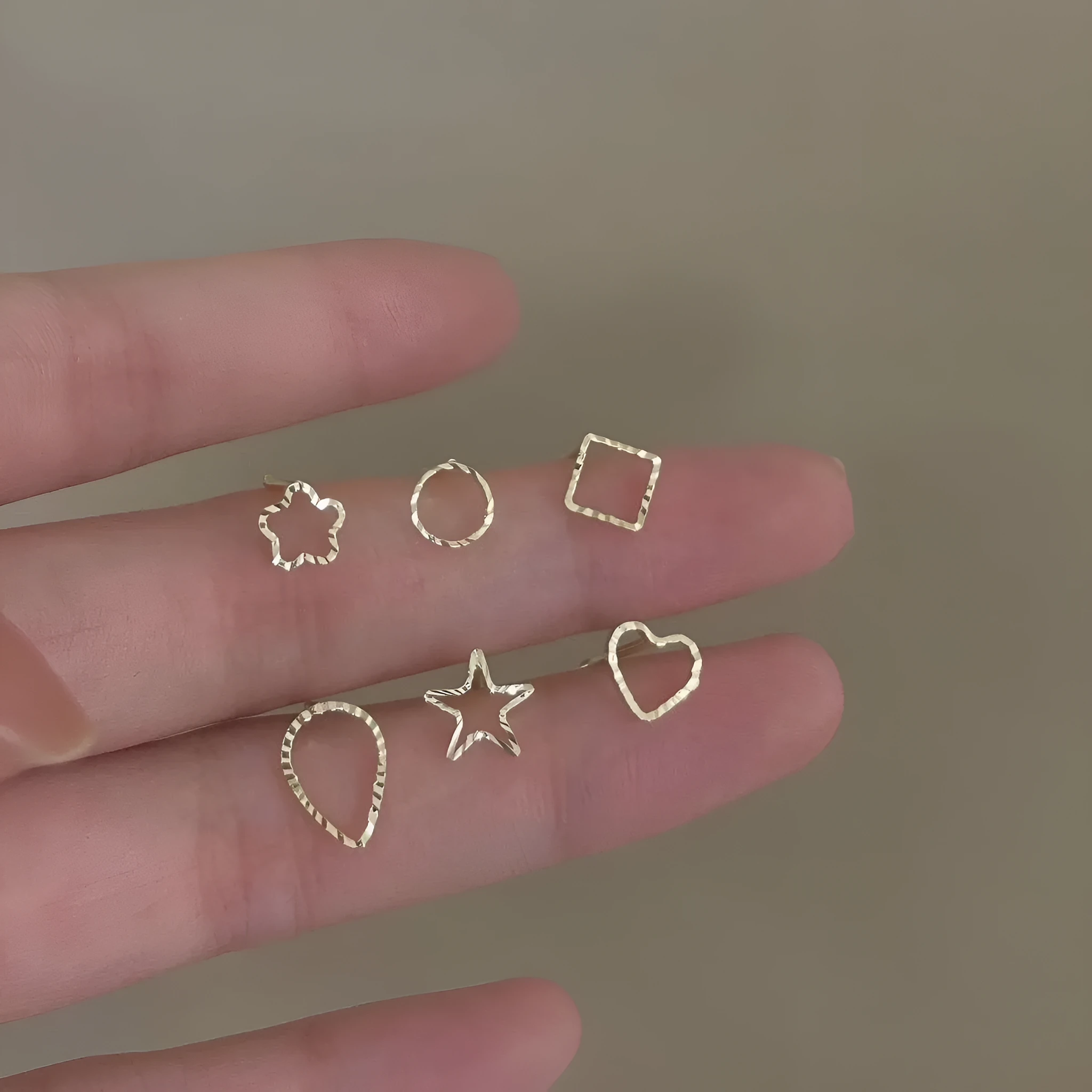 Small spiral geometric ear studs in gold hollow thread design with mixed material build and electroplated finish