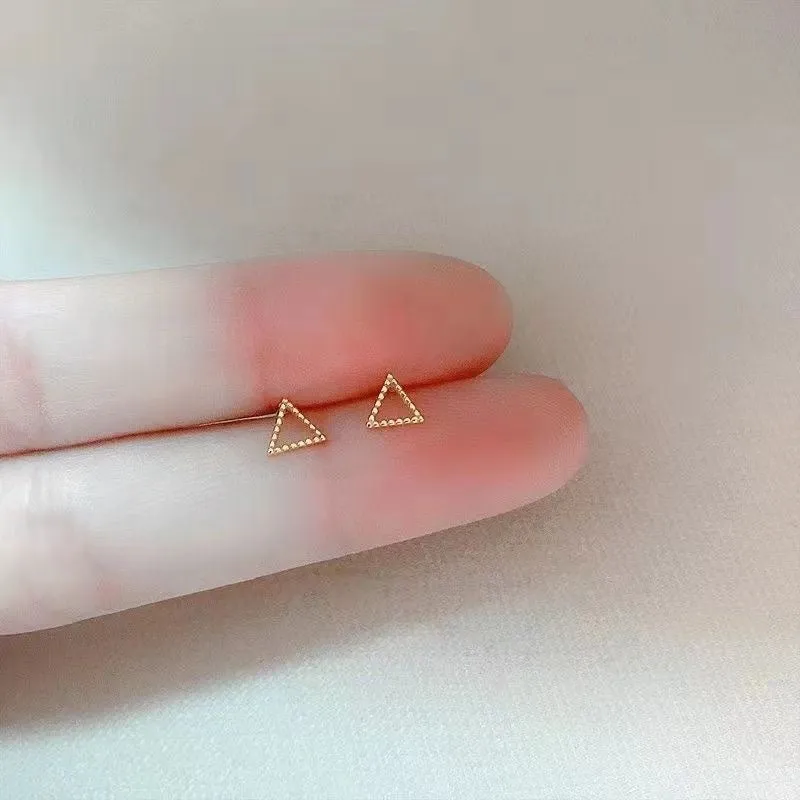 Small spiral geometric ear studs in gold hollow thread design with mixed material build and electroplated finish