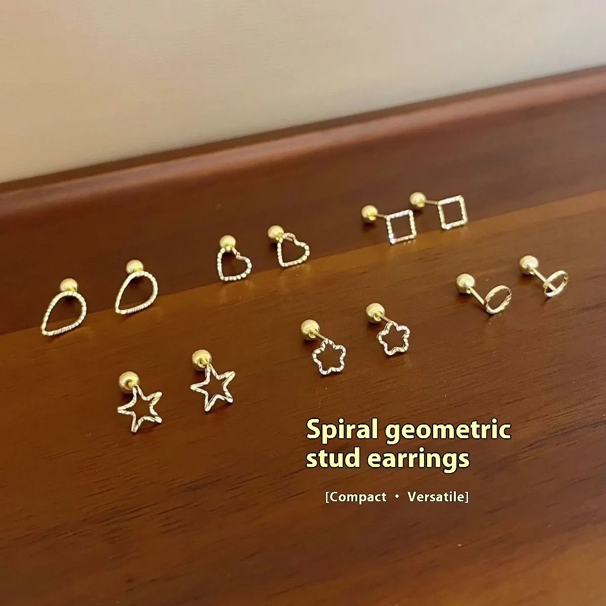 Small spiral geometric ear studs in gold hollow thread design with mixed material build and electroplated finish