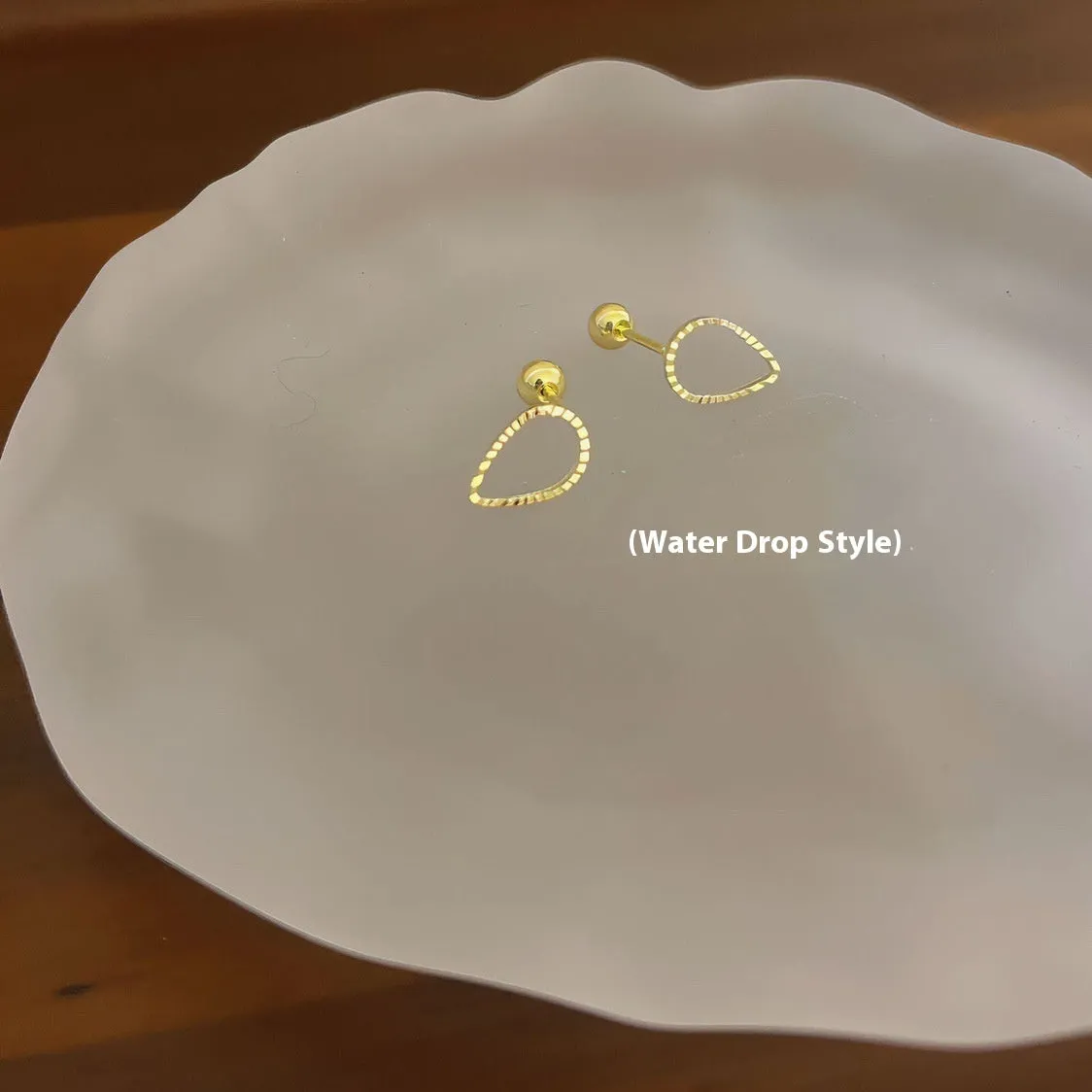 Small spiral geometric ear studs in gold hollow thread design with mixed material build and electroplated finish