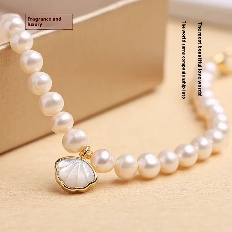 A women's freshwater pearl bracelet with a fan-shaped shell clasp, shown in both elastic and extension chain fastening styles.