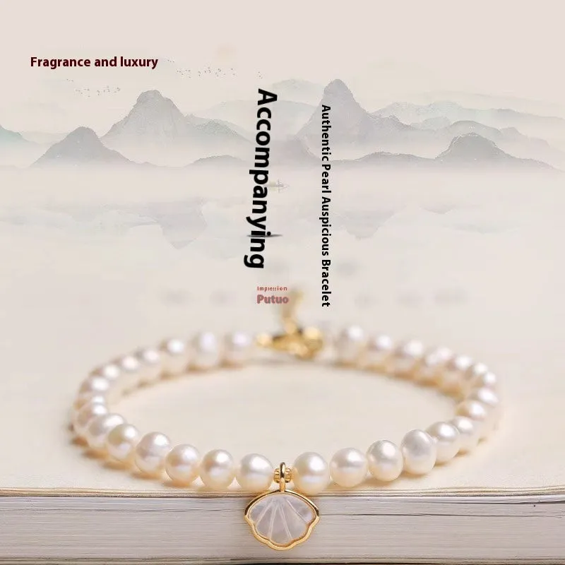 A women's freshwater pearl bracelet with a fan-shaped shell clasp, shown in both elastic and extension chain fastening styles.